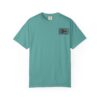 A teal t-shirt with a small rectangular patch on the chest.