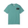 A teal short-sleeve t-shirt with a small graphic on the chest pocket.