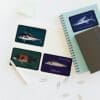 Four playing cards with shark illustrations placed near a notebook and pen.