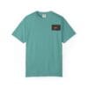 A teal short-sleeve t-shirt with a small black and red patch on the chest.