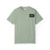 Light green t-shirt with a small black and purple rectangular patch on the chest.