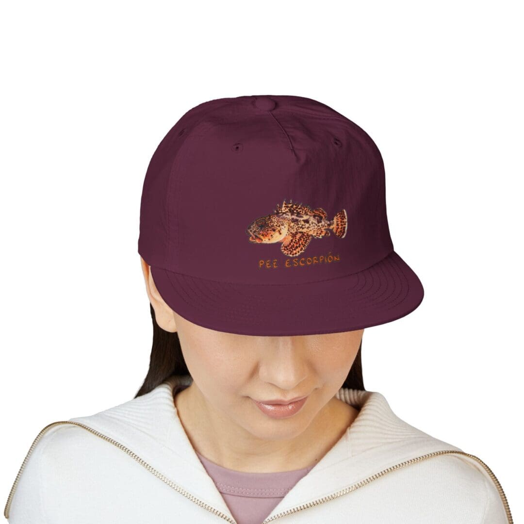 Person wearing a maroon baseball cap with a brown logo.