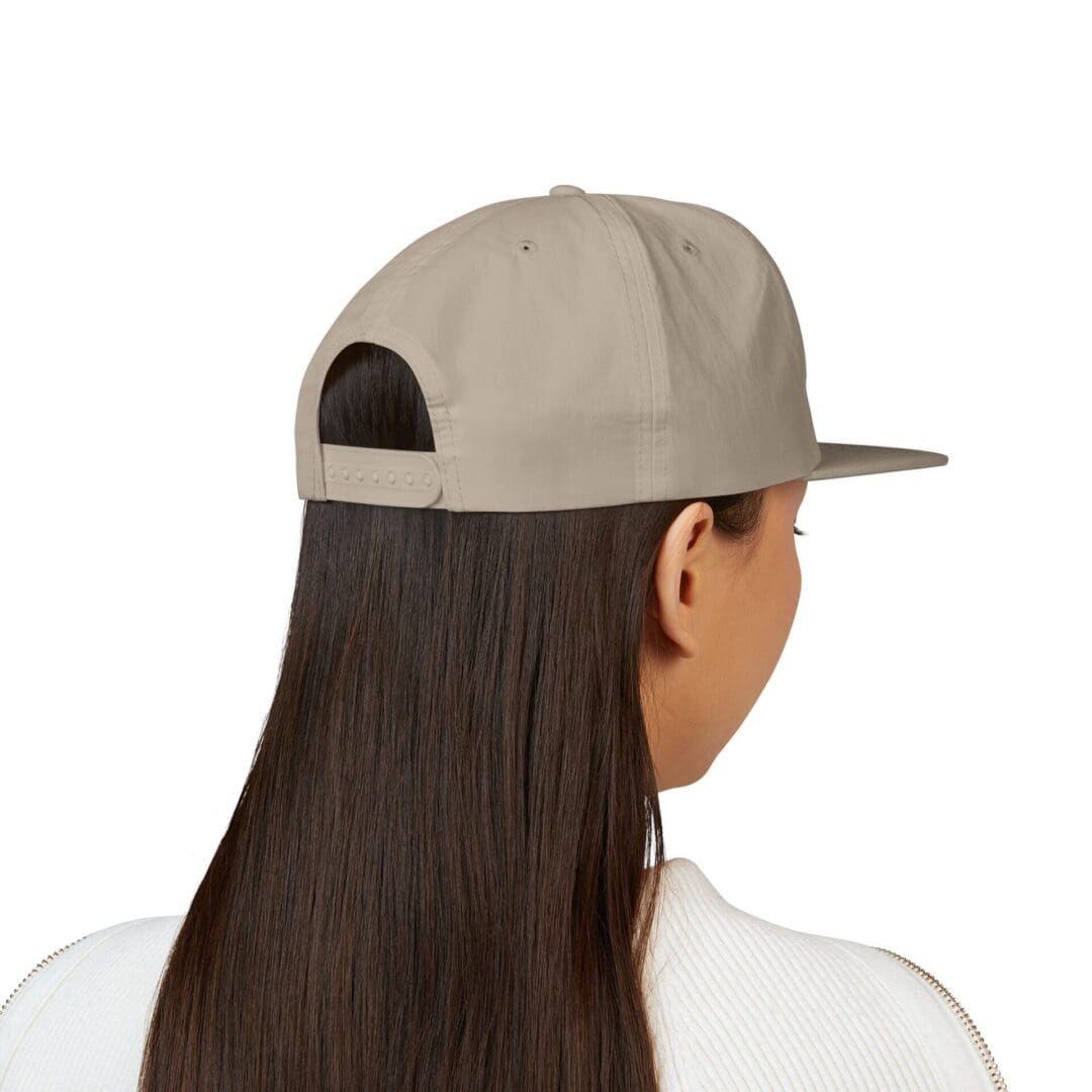Rear view of a person wearing a beige cap and white shirt.