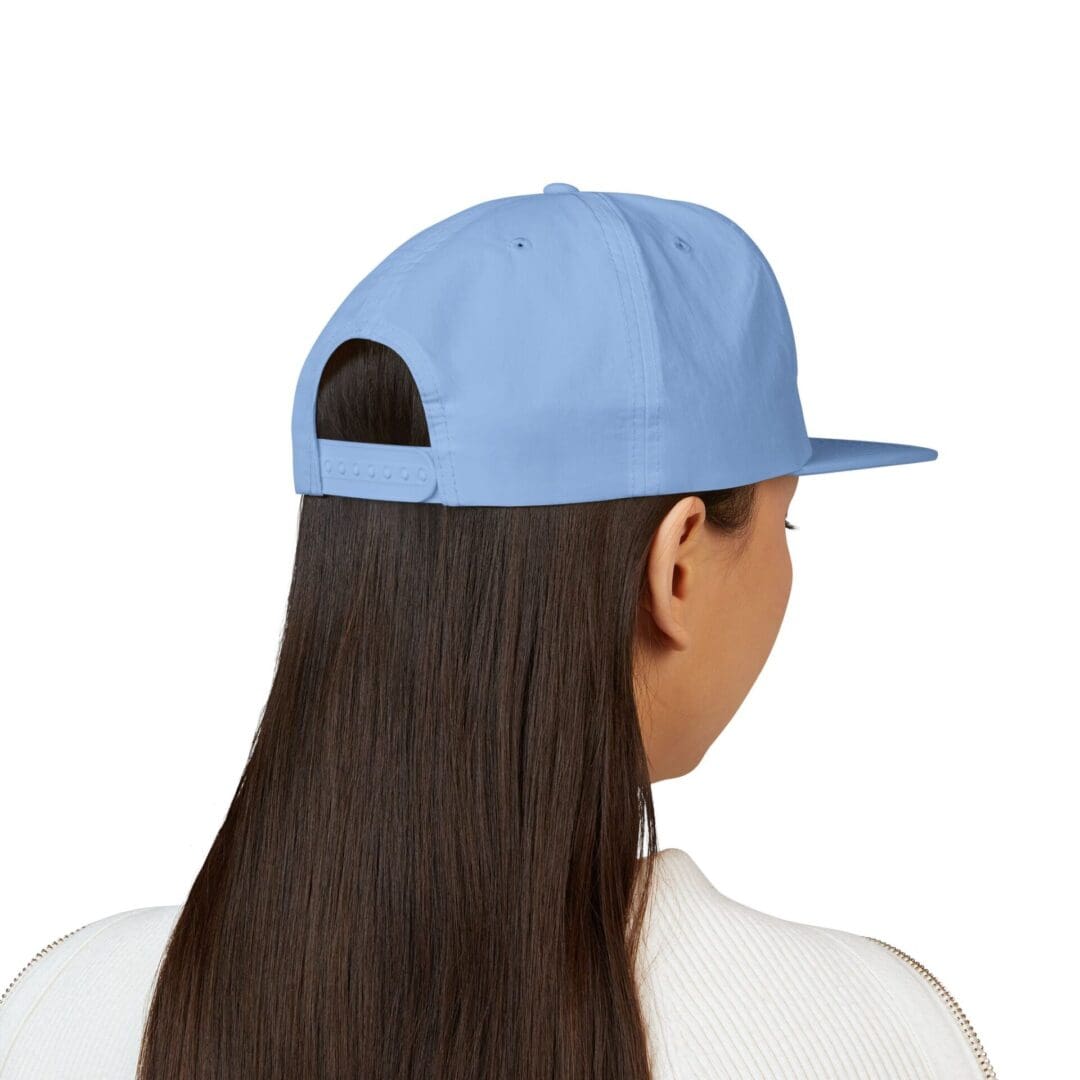 Back view of a person wearing a blue cap and white shirt.