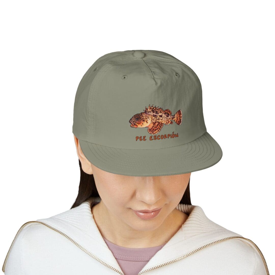 Person wearing a gray baseball cap with a fish graphic and text.