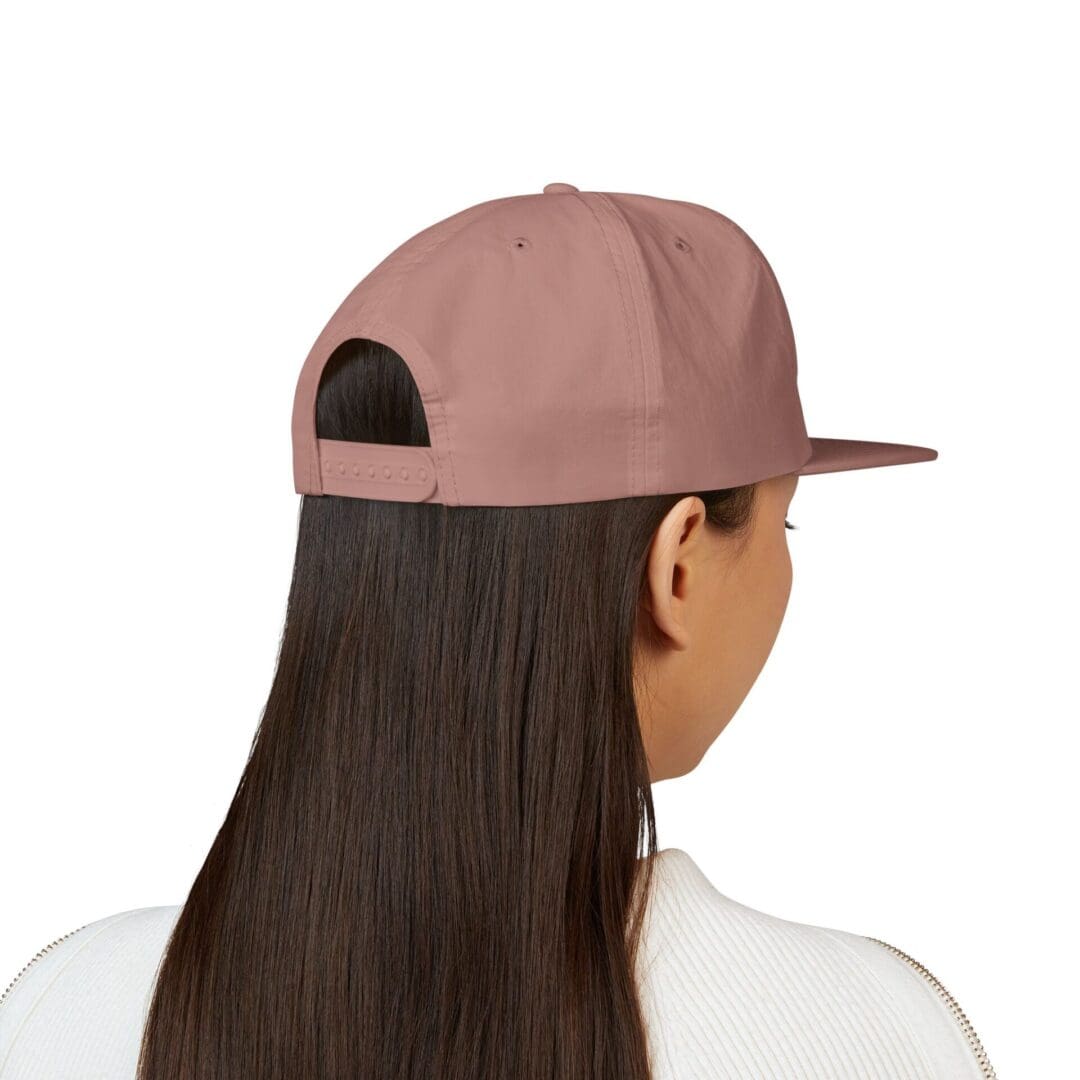 Person with long hair wearing a backward pink cap.