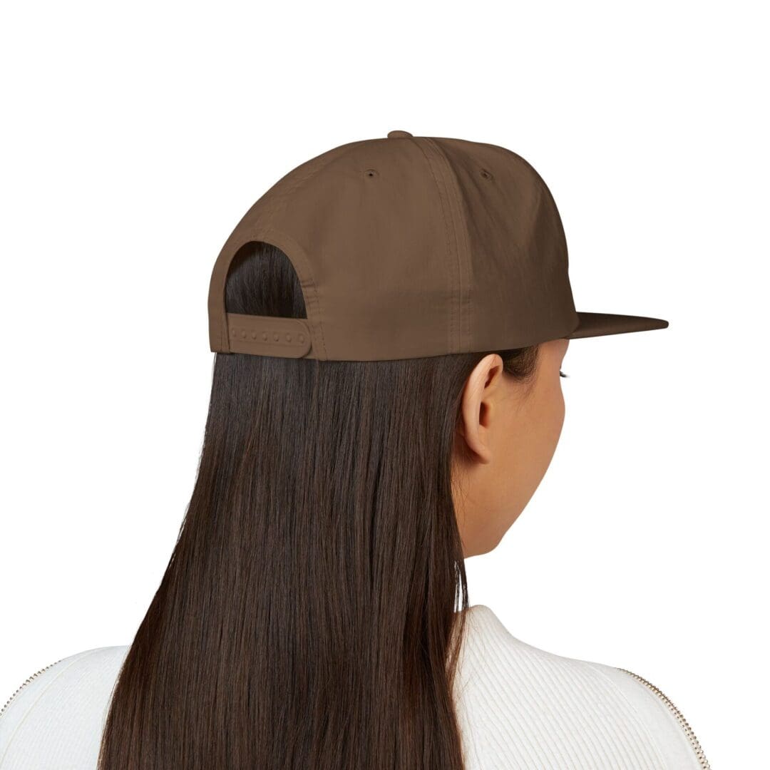 Person with long hair wearing a brown cap, viewed from behind.