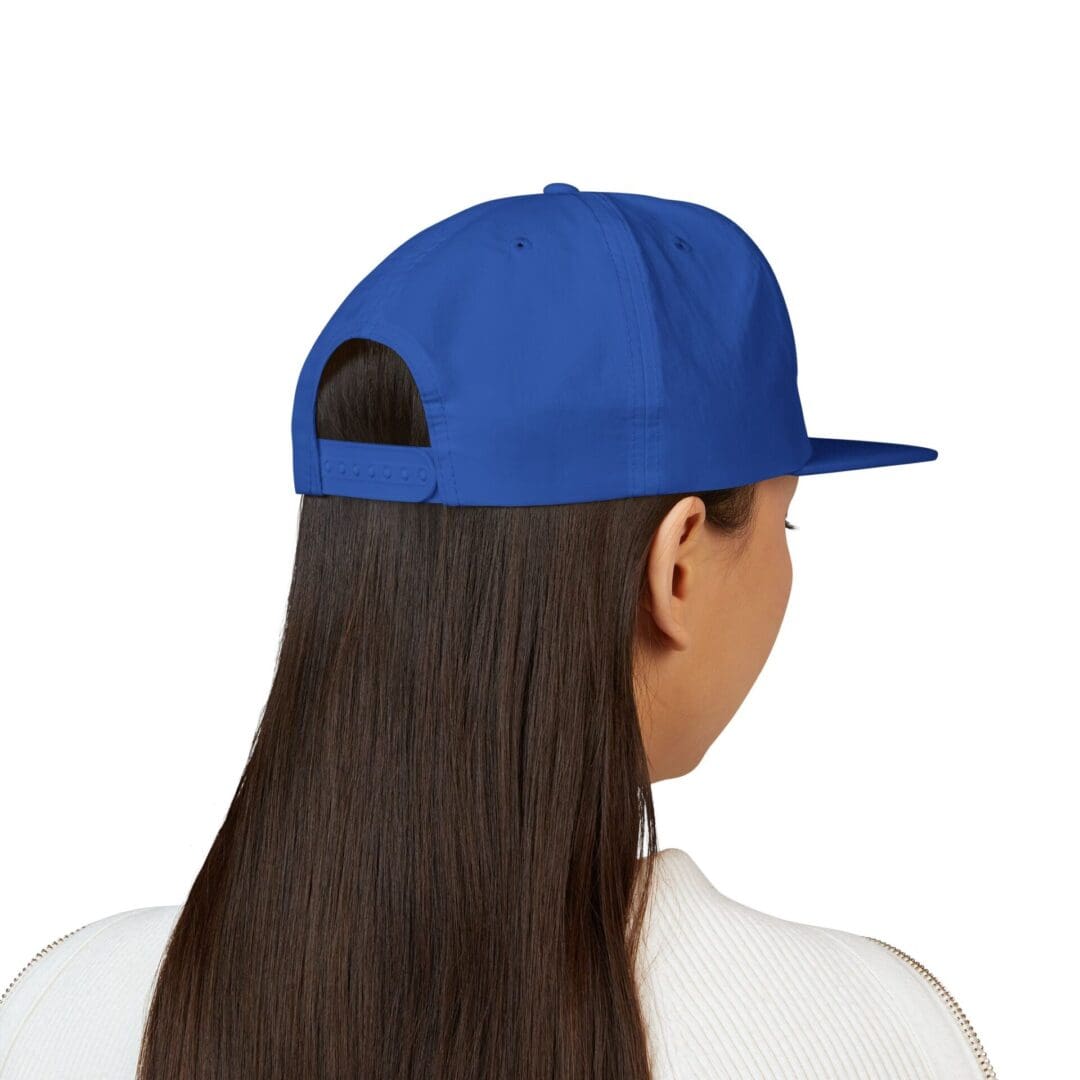 Person wearing a blue cap facing away with long straight hair.