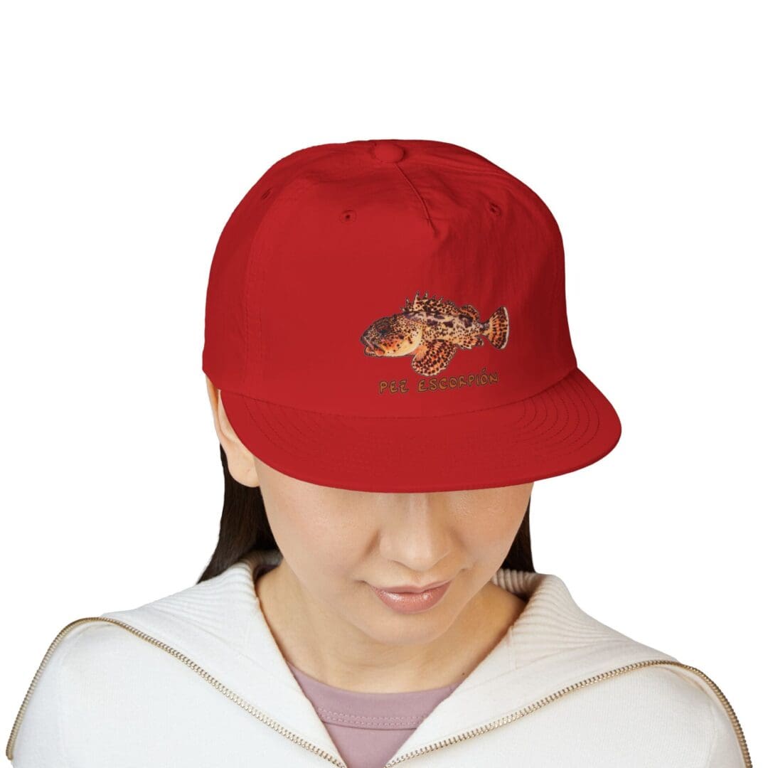 Person wearing a red cap with a graphic design, looking downward.