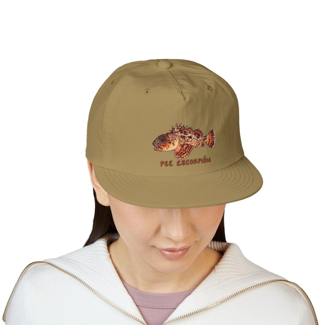 Person wearing a beige baseball cap and white hoodie, looking down.