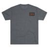 Gray T-shirt with a small red and black rectangular logo on the chest pocket area.