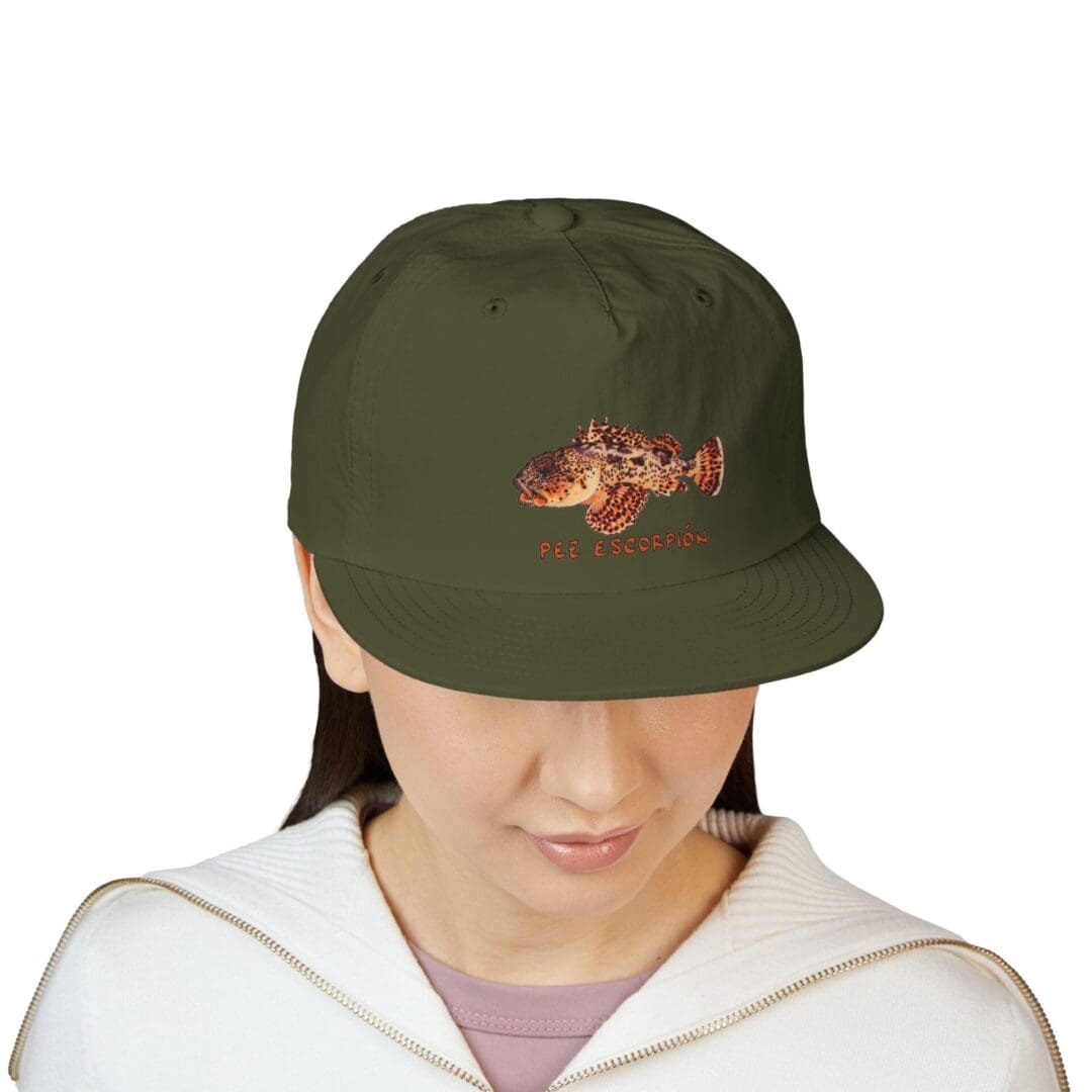 Person wearing an olive green baseball cap with orange text.
