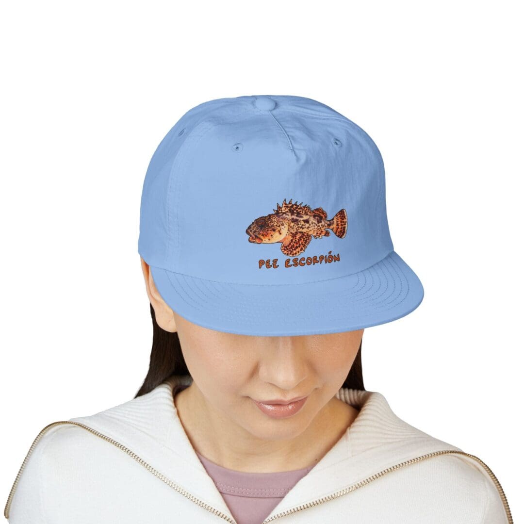 Person wearing a blue cap with a bear and text design.