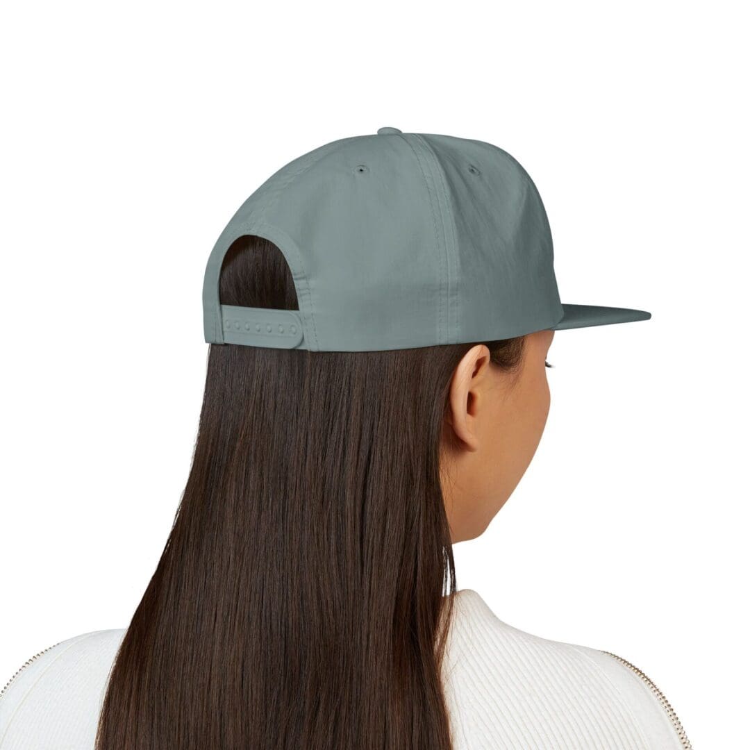 Back view of a person wearing a light blue baseball cap and white shirt.