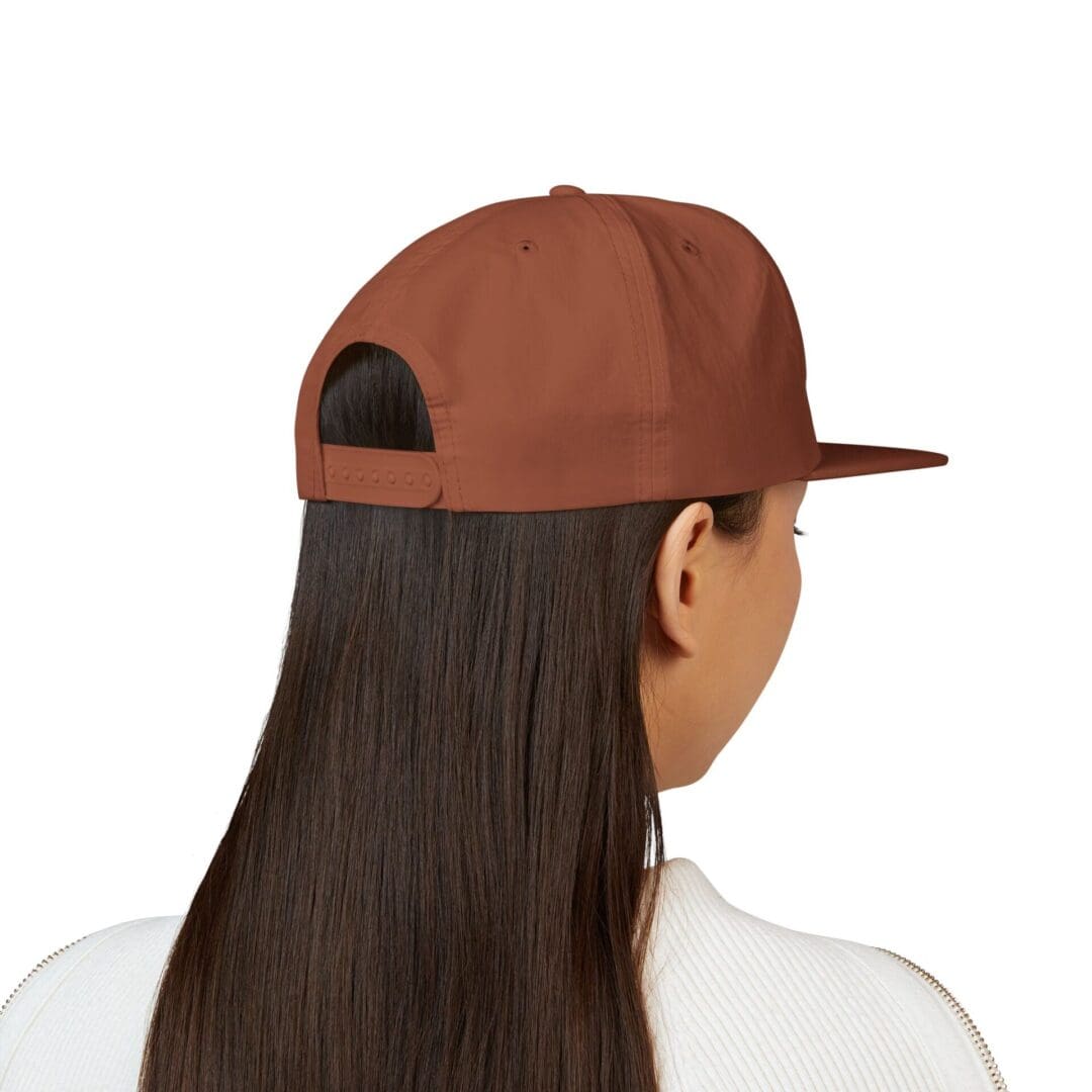 Back view of a person wearing a brown cap and white shirt.