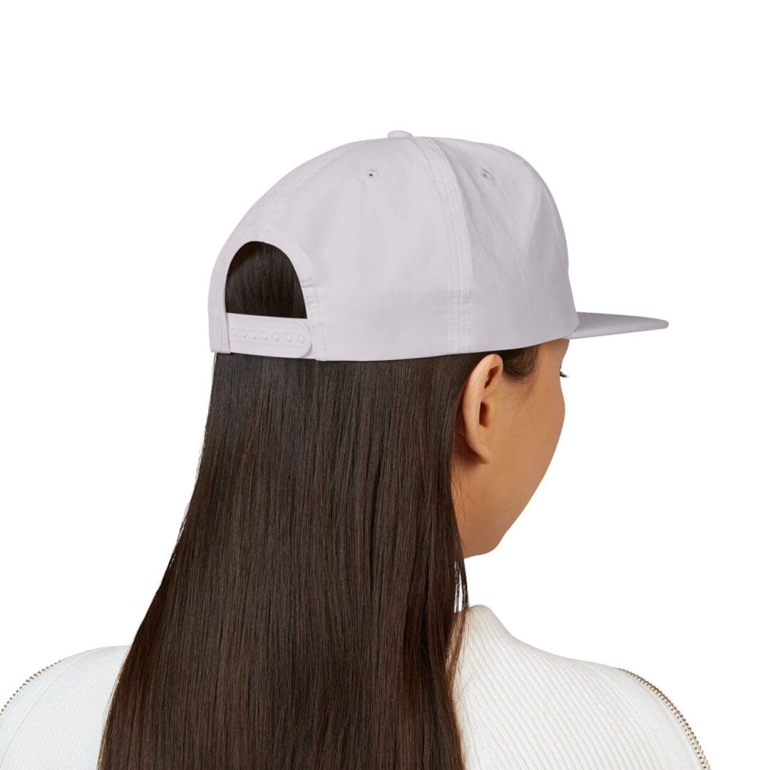 Rear view of a person wearing a white baseball cap and long straight hair.