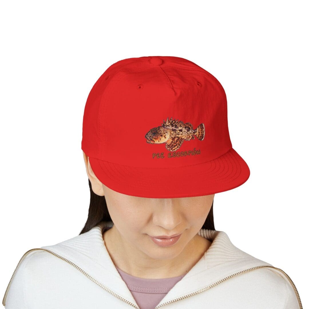 Person wearing a red baseball cap with a logo, looking downward.
