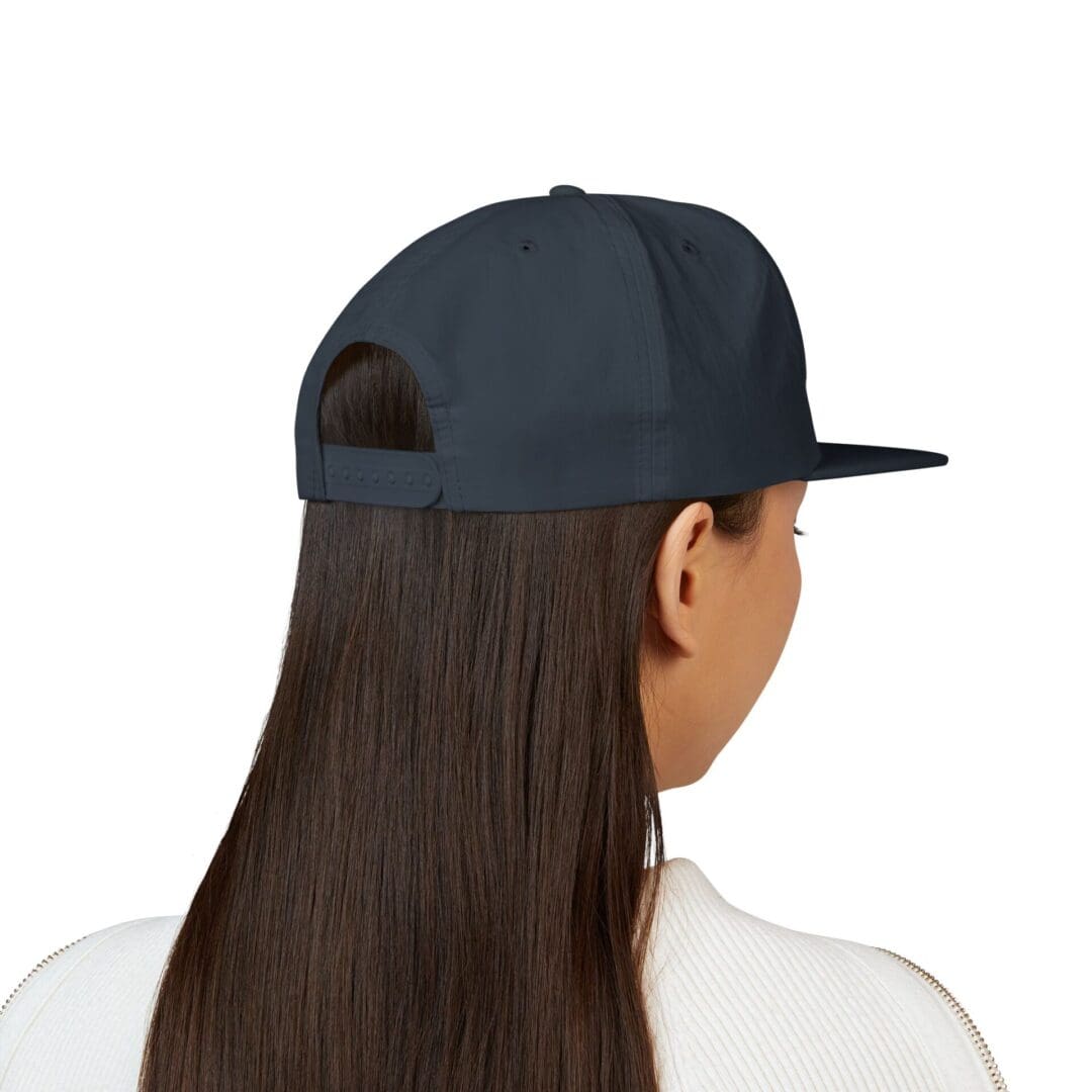 Person with long hair wearing a black baseball cap backwards.