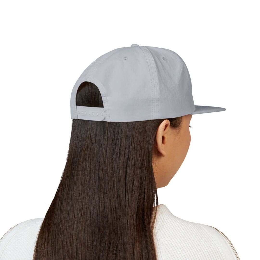 Rear view of a person with long hair wearing a gray baseball cap.