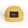 Yellow cap with a black patch featuring a bird design.