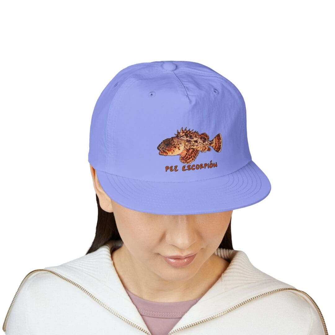 Person wearing a light blue cap with a fish design.