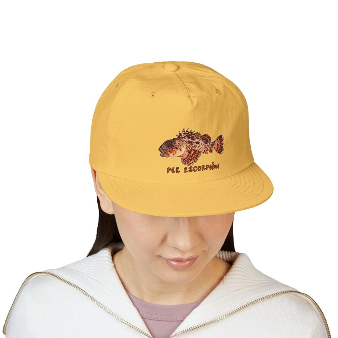 Person wearing a yellow cap with a dinosaur graphic and the text 'Jurassic Park'.